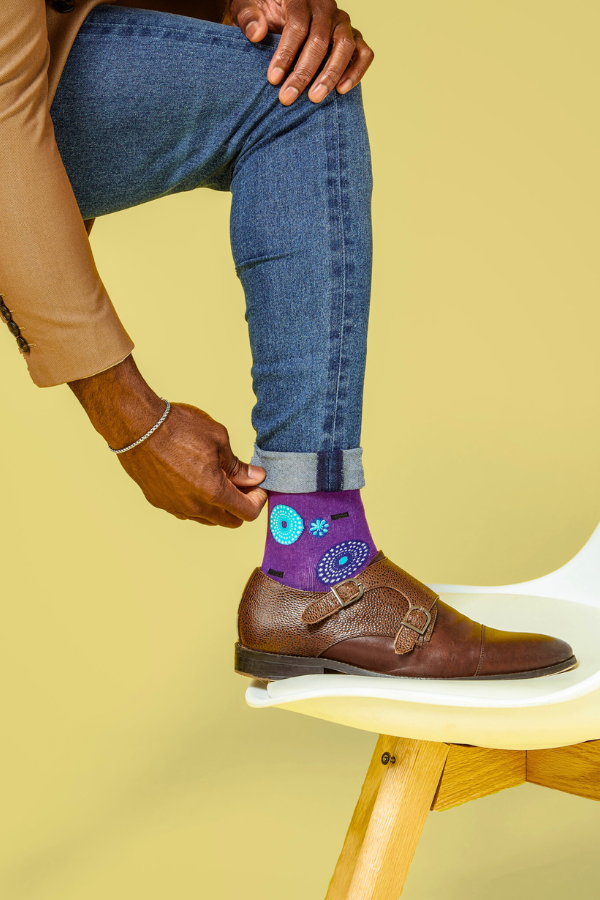 Purple socks. The Ghanaian name for the textile that inspired this design is Nsu Bra, an Akan word meaning "water well". The tiny dots are meant to resemble the ripples that are formed after water has been fetched.
In Nigeria, it is referred to as "disk" or "record" for obvious reasons.
In Togo, it is known as Gbedze, which references the straw hats worn as protection from the sun by royalty.